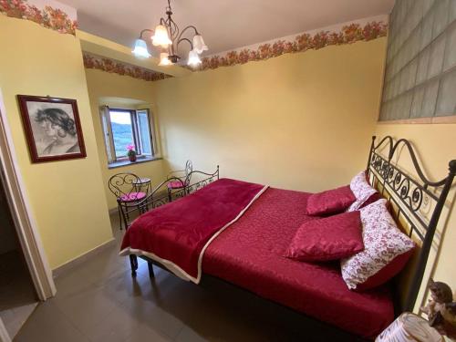- une chambre avec un lit et une couverture rouge dans l'établissement Casa vacanze Il Geranio, à Celleno