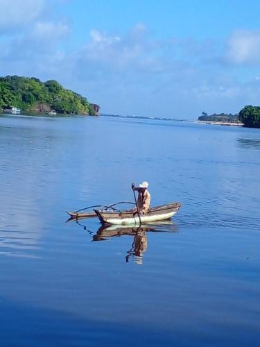 a man is rowing a boat in the water at Ora in Kalutara