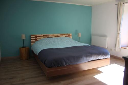 sypialnia z dużym łóżkiem z drewnianym zagłówkiem w obiekcie Gîte champêtre Al Wèrihè w mieście Lierneux