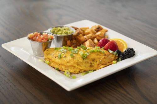 a plate of food with chicken and french fries and fruit at Four Points by Sheraton Tucson Airport in Tucson