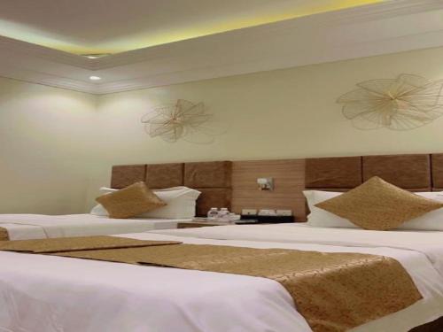 a hotel room with two beds with white sheets at شقق فاخريه جده in Jeddah