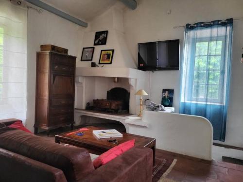 un salon avec un canapé et une table dans l'établissement Maison Péchelune, à Correns