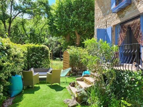 un jardin avec des chaises et une table sur l'herbe dans l'établissement Maison Péchelune, à Correns