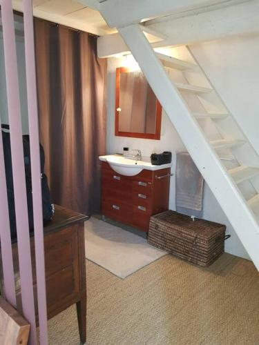La salle de bains est pourvue d'un lavabo et d'une coiffeuse avec un miroir. dans l'établissement Maison Péchelune, à Correns