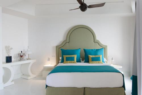a bedroom with a large bed with blue pillows at Hotel Miramalfi in Amalfi