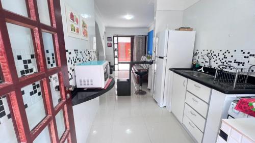 uma cozinha com um frigorífico e um micro-ondas em Condominio Village Americana em Ubatuba