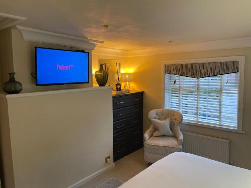 鲍特里Cosy Cottage Central Bawtry - 2 Bedroom - High End Furnishings的一间卧室配有电视、椅子和梳妆台