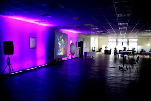 a room with purple lights and a room with chairs at Hotel Austeria Conference & Spa in Ciechocinek