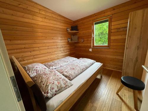 a small room with a bed in a wooden room at Camping Hierhold in Kumberg