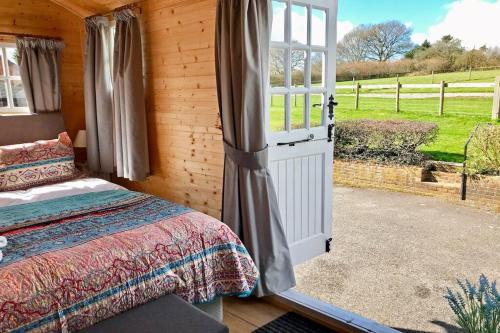 a bedroom with a bed and a large window at Arniss Farmhouse in Fordingbridge