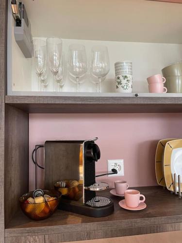 a kitchen with a coffee maker and glasses on a shelf at Sonniges und stylisches Loft mit toller Aussicht in Ufhusen
