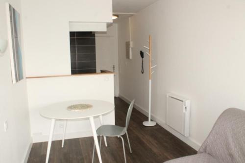 a small kitchen with a white table and chairs at Résidence Le Crystal Dinard Plage in Dinard