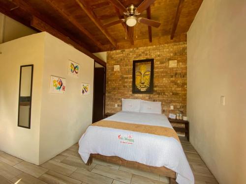 a bedroom with a bed and a brick wall at Hotel Villas Mariposas in Atlixco