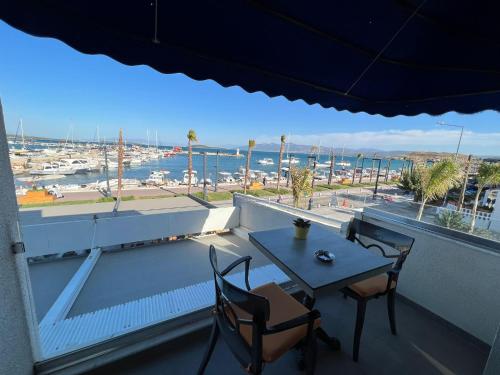 Urla Marin otel في إزمير: طاولة وكراسي على شرفة مطلة على ميناء