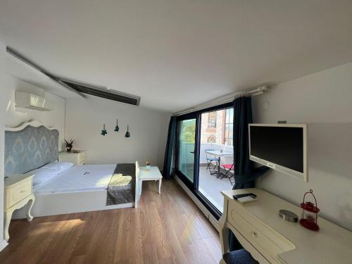 Schlafzimmer mit einem Bett, einem Schreibtisch und einem TV in der Unterkunft Urla Marin otel in Izmir