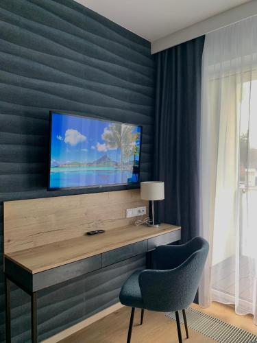 a living room with a television on a wall at REMAR - Apartamentai prie Biale Ežero in Augustów
