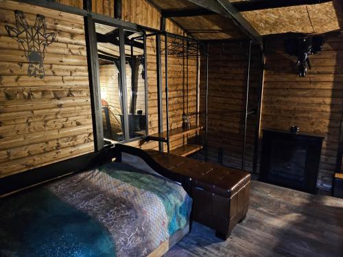 a bedroom with a bed in a room with a fireplace at le petit chalet cevenol in La Barriére