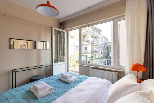 a bedroom with a bed and a large window at Modern & Newly furnished 1BR Flat w/ Balcony & AC in Istanbul