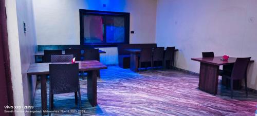 a dining room with wooden tables and chairs at POP Hotel Harsh in Aurangabad