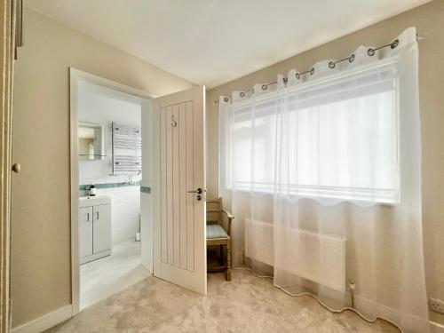 a bathroom with a shower curtain and a window at Incredible Views in Dartmouth with Parking and EV Charger in Dartmouth