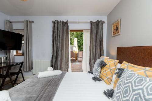 um quarto com uma cama, uma secretária e uma televisão em The Gower Hotel em Swansea