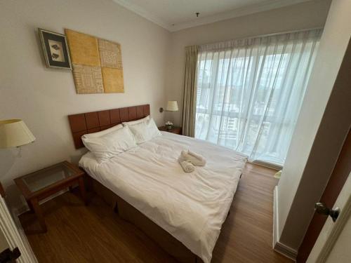 ein Schlafzimmer mit einem Bett mit einem ausgestopften Tier darauf in der Unterkunft StayInn Gateway Hotel Apartment, 2-bedroom Kuching City PrivateHome in Kuching