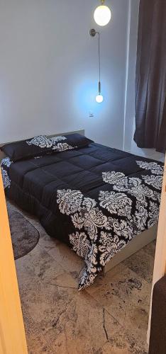 Ce lit se trouve dans une chambre dotée d'une couverture noire et blanche. dans l'établissement Massilia New'z appart 02, à Marseille