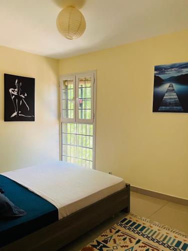 Schlafzimmer mit einem Bett und einem Fenster in der Unterkunft Superbe appartement T3 à Pamandzi in Pamandzi
