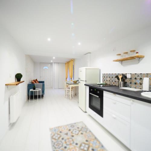 Il comprend un salon et une cuisine équipée d'appareils électroménagers blancs. dans l'établissement NOUVEAUTE 2024 Appartement Design avec jardin, à Bellerive-sur-Allier