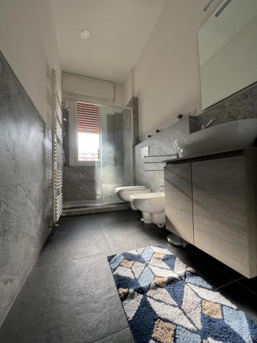 a bathroom with a sink and two toilets at Appartamento Barbieri in Bologna