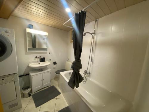 ein weißes Bad mit einer Dusche und einem Waschbecken in der Unterkunft Apart'Hotel du Faubourg by Stay Swiss in Pruntrut