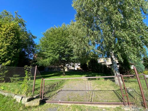 an old gate in a field with a tree at rekreační dům Pohoda in Jiřetín pod Jedlovou