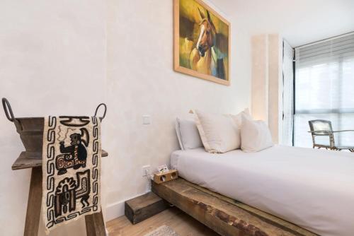 sypialnia z łóżkiem i obrazem na ścianie w obiekcie CajaSoul by Caja Mágica Madrid w Madrycie