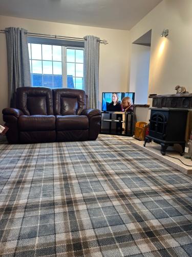 a living room with a couch and a tv at 14 Upper Bayble in Stornoway