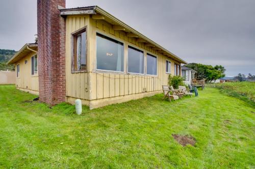 a small yellow house on a grass field at Rustic Coastal Smith River Cottage with Ocean Views! in Smith River