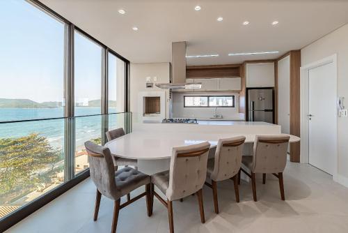 a kitchen and dining room with a table and chairs at Apto moderno com vista para o mar LLR802 in Porto Belo