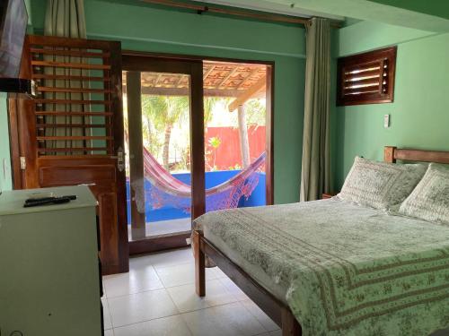 a bedroom with a bed and a sliding glass door at DECK HOUSE in Tatajuba