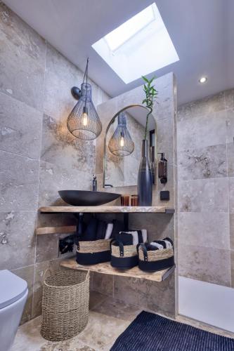 une salle de bain avec un lavabo et un miroir dans l'établissement Les Jasmins en Provence, à LʼIsle-sur-la-Sorgue