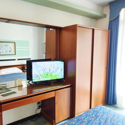 a bedroom with a desk with a television on it at Casaalbergo La Rocca in Noale