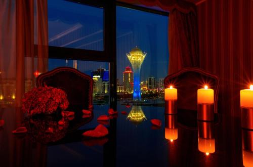 a room with a table with candles and a view of the city at Diplomat Hotel by AG Hotels Group in Astana