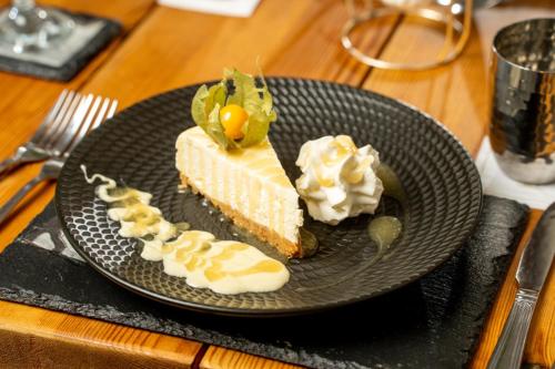 a piece of cake on a black plate on a table at The Gower Hotel in Swansea