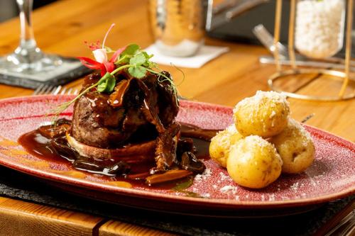 a plate of food with meat and potatoes on a table at The Gower Hotel in Swansea