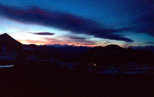 a sunset over a mountain range with a cloudy sky at Albergo Quarto Pirovano in Passo Stelvio