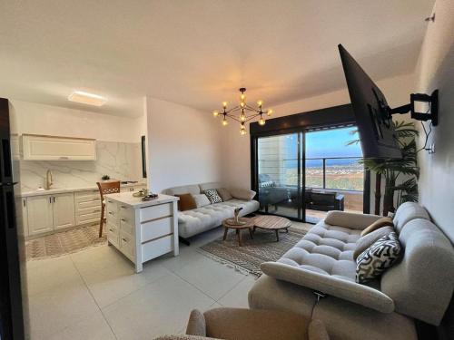 a living room with a couch and a kitchen at LUXURY HOUSE AKKO in ‘Akko