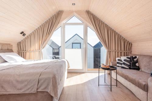 Un dormitorio con una cama y un sofá y una ventana. en Tropicana Gold, en Bobolin