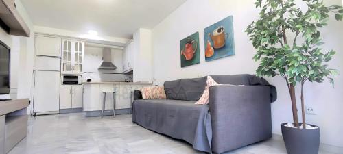 a living room with a couch and a potted tree at Laguna Green Apartment in Torrox Costa