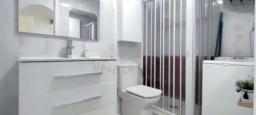 a white bathroom with a toilet and a sink at Laguna Green Apartment in Torrox Costa