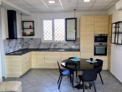 a kitchen with a table and chairs in a room at Casa Zefiro, tra pineta e mare! in Fregene