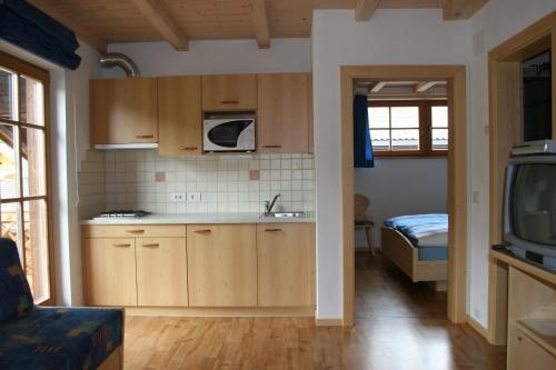 a kitchen with wooden cabinets and a bed in a room at Valtnerhof in San Candido