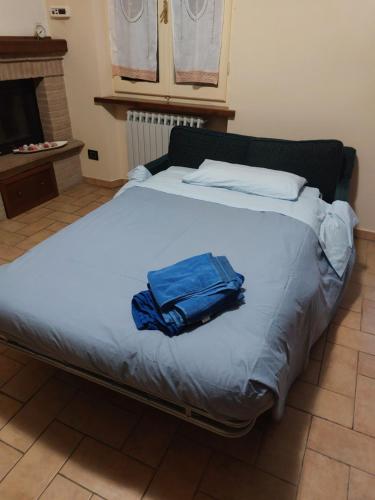 ein großes Bett mit blauem Handtuch drauf in der Unterkunft Montemartano in Spoleto